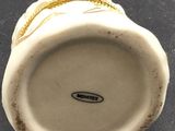 a close up of a white vase with a chain on it
