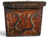 an old wooden box with two snakes painted on it