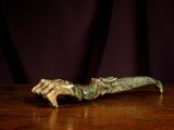 bronze figurine of a hand holding an umbrella on a wooden table