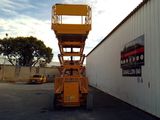 a yellow lift truck parked in front of a building
