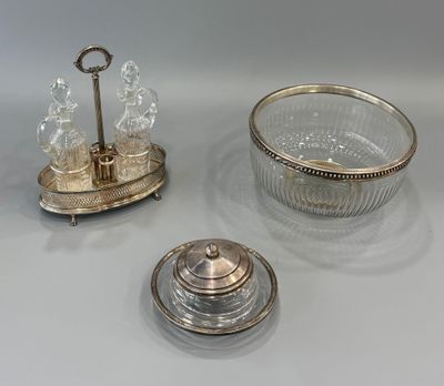 two silver plated dishes and a glass bowl on a table