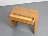 a small wooden table with a drawer on it