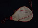 a small leather bag with a red handle on a black surface