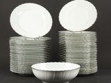 plusieurs assiettes empilées les unes sur les autres, avec un bol devant elles