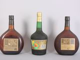three bottles of liquor sitting next to each other on a table
