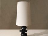 une lampe noire avec un abat-jour blanc posée sur une table