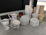 a lot of plates and cups on the counter