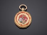 an image of a gold and enamel pocket watch on a black surface