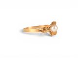 a close up of a gold ring with a pearl in the middle