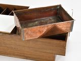a wooden box with a metal lid on a white surface