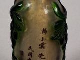 a small glass bottle with writing on it sitting on a table