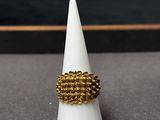 la bague en or repose au sommet d'un cône blanc