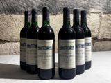 quatre bouteilles de vin sont alignées sur une table