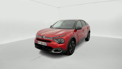 une voiture rouge dans une pièce blanche au sol blanc