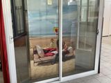 two people lounging on a couch in a room with sliding glass doors