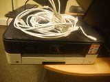 a printer with a bunch of cords on top of it