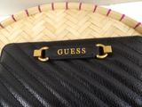 a black purse sitting on top of a wicker basket