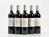 quatre bouteilles de vin rouge sont alignées sur une surface blanche
