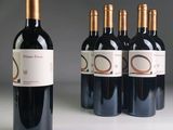quatre bouteilles de vin rouge sont alignées sur une table