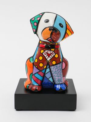 ceramic sculpture of a dog sitting on a black base