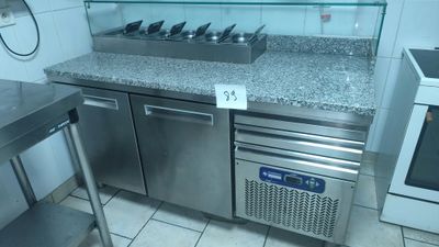 a stainless steel counter top with a glass shelf above it