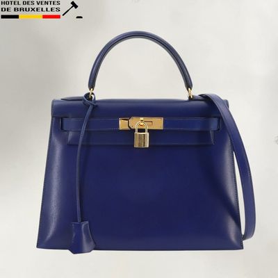 a blue handbag with a gold lock on the handle