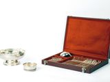 une coupe en argent et une assiette en argent dans un coffret en bois