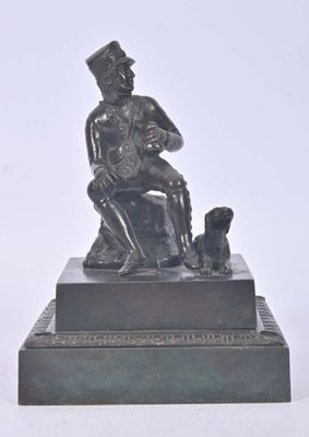 statue of a man sitting on a chair with a dog
