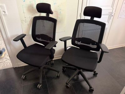 deux chaises de bureau noires posées l'une à côté de l'autre sur le sol