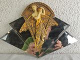 a person taking a picture of a mirror with an angel on it