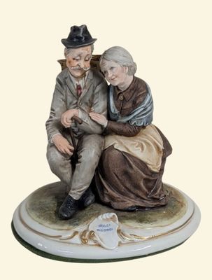 a figurine of a man and a woman sitting on a bench