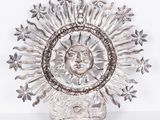 a silver plate with a sun and stars on it
