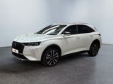 un SUV blanc garé dans une pièce blanche au sol noir