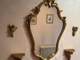 a mirror on the wall above a radiator in a room