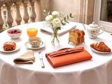 a white table with a white table cloth and orange napkins