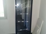 a black refrigerator in the corner of a room