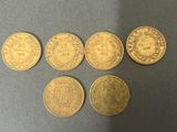 a group of five gold coins sitting on top of a table