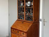 un meuble en bois avec une porte en verre dans le coin d'une pièce