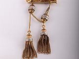 a close up of a pair of tassels on a white surface