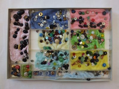 une boîte remplie de boutons et des boutons posés sur une table