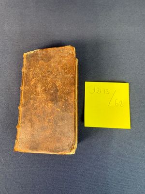 un vieux livre posé sur une table, à côté d'un post-it jaune