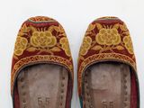 pair of red and gold slippers with floral design on them