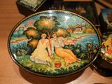 a plate with a painting on it sitting on a table