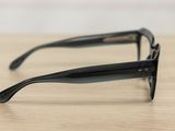 sunglasses on a wooden table with a white wall in the background