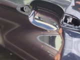 a reflection of a man in a mirror on a car ' s hood