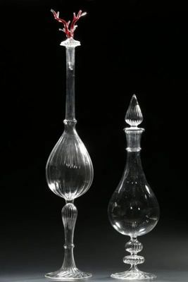 deux vases transparents contenant des fleurs rouges, sur fond noir