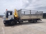 un camion blanc équipé d'une cage à l'arrière, garé sur un parking