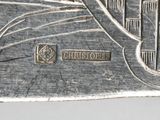 a silver plate with a picture of a city on it