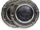 three silver plates on top of each other on a white surface