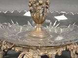 a silver plate with a glass vase on top of it